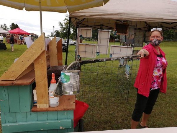 Harvest of Artists a Huge Success Artist and organizer Sherie Gladu with a homemade gadget to give people their change and respect social distance guidelines.